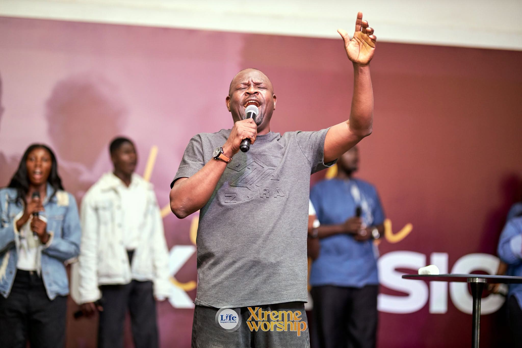 A worship leader with one arm raised