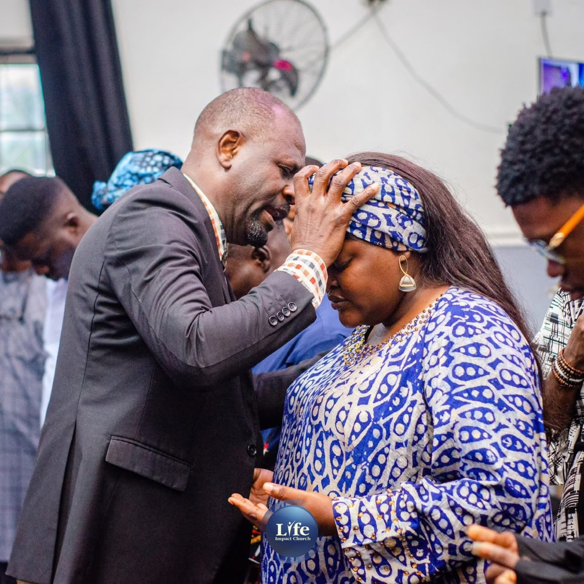 A pastor praying over a member of the church