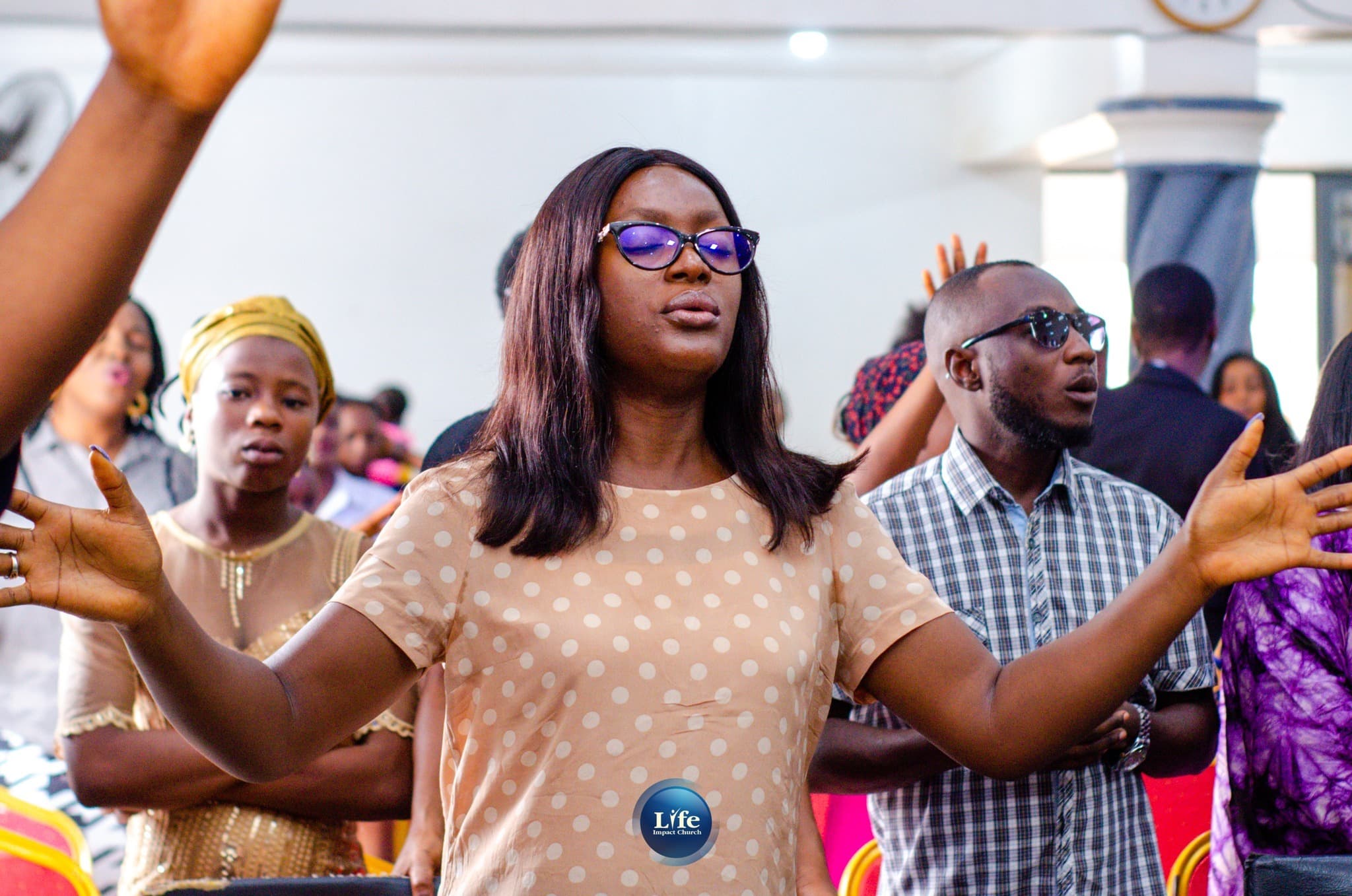 A woman worshipping with her arms open