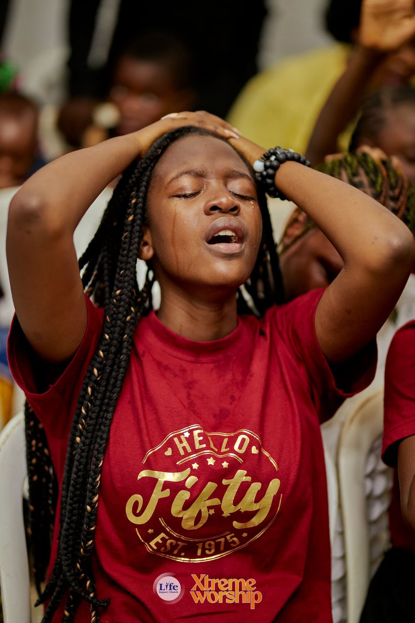 A young woman lifting her hands in worship